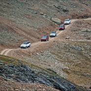 Land Rover vehicles driving along a narrow pass