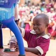 A pupil from Exodus Academy takes water from a LifeStraw container 