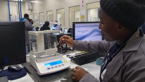 Diamond stock controller checking rough diamond weight at a De Beers facility. Image courtesy of De Beers Group