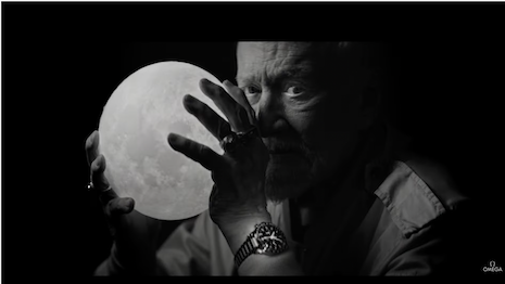 A picture of astronaut Buzz Aldrin holding a moon replica. 