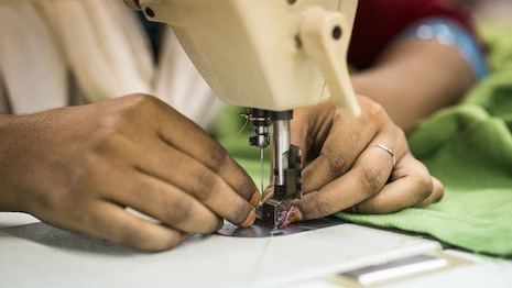 Photo of garment worker's hand at sewing machine