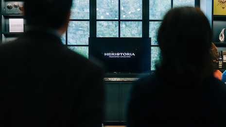 Photo of two individuals observing screen with LVMH Herstoria displayed