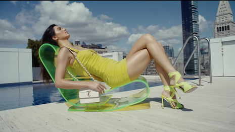 Ms. Jenner lounges above the city skyline, evoking the superheroine theme at the heart of the collection. Image credit: Jimmy Choo