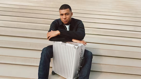 The soccer sensation poses with the “Classic Cabin in silver” suitcase. Image credit: Rimowa
