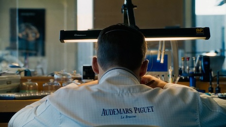 Craftspeople are shown doing their jobs at the Le Brassus office, stopping and waving for the camera. Image credit: Audemars Piguet